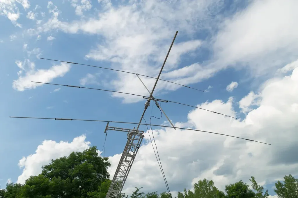 Antena kierunkowa typu Yagi na kratowym maszcie na tle chmur