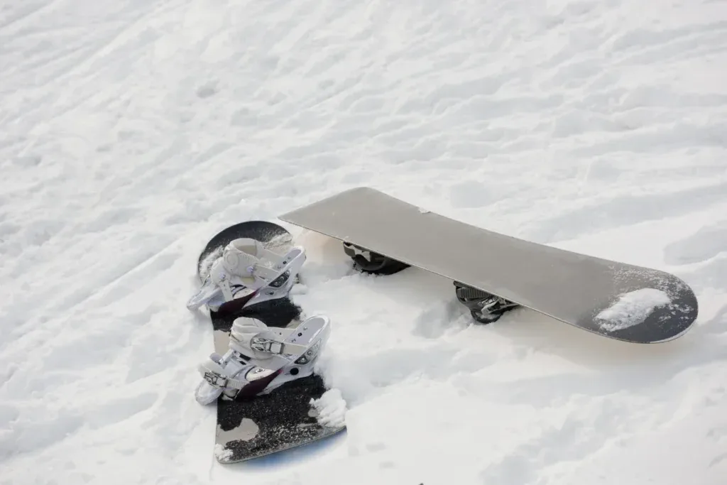 Deska snowboardowa z wiązaniami leżąca na śniegu